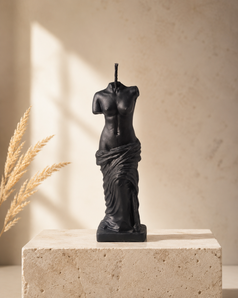 Black sculptural figure candle with draped texture and cotton wick